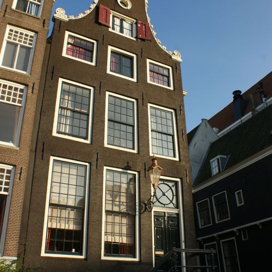 Pand met klokgevel bekroond door twee horens van overvloed