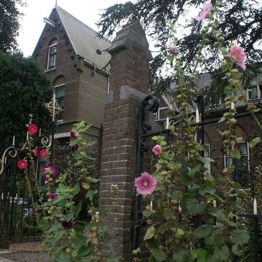 IJzeren hek tussen bakstenen pijlers als erfscheiding aan de straatzijde, behorend bij het complex 'St. Urbanuskerk te Nes aan de Amstel'