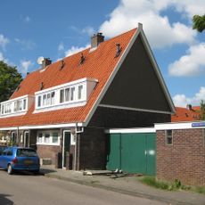 Blok met 4 keukenwoningen, zo genoemd vanwege destijds nieuwe plaatsing van keuken aan de voorzijde, aan de zijkant een houten topgevel, bouwstijl Amsterdamse School.