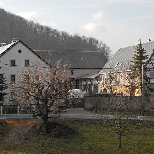 Wohnstallhaus und zwei Seitengebäude eines Dreiseithofes, mit hölzerner Inschrifttafel Dorfstraße 3