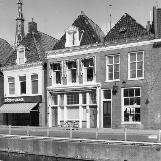 Pand met rechte kroonlijst met blokjes onder zadeldak met voorschild en dakkapel