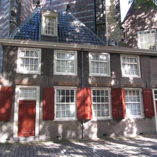 Tegen de oude kerk gebouwd huis ten dele onder plat-, ten dele onder schilddak