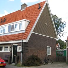 Blok met 4 keukenwoningen, zo genoemd vanwege destijds nieuwe plaatsing van keuken aan de voorzijde, aan de zijkant een houten topgevel, bouwstijl Amsterdamse School.