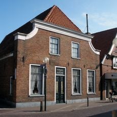 Hoekpand met ingezwenkte lijstgevel op plint