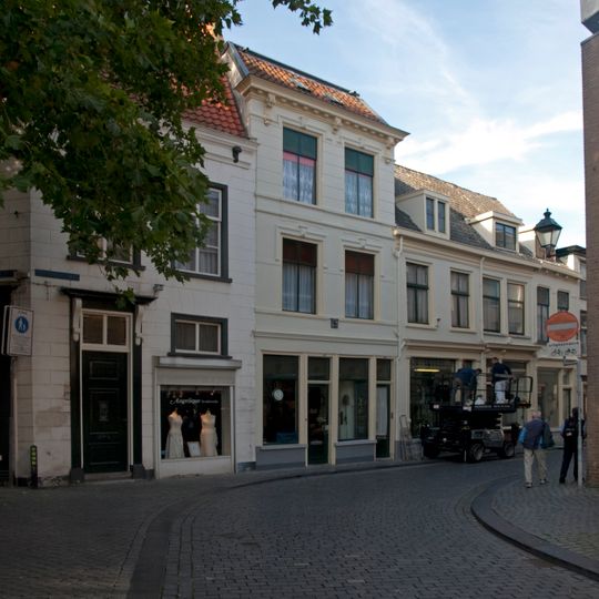 Huis met gebosseerd gepleisterde lijstgevel en kroonlijst op consoles