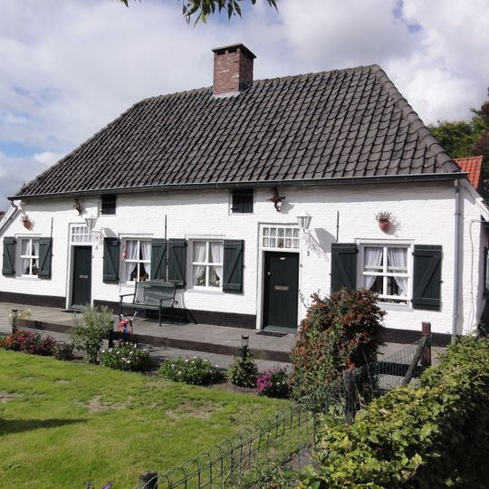 Twee gepleisterde landarbeidershuisjes onder een pannen wolfsdak