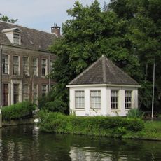 Speelhuis, gepleisterd rechthoekig gebouwtje onder met pannen gedekt tentdak. Op het terrein van het Huis "Middendorp" aan de Vliet