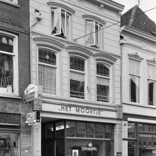 Pand met gepleisterde lijstgevel en jongere winkelpui