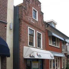 Pand met enig overgebleven authentieke smalle gevel met klimmend boogfries