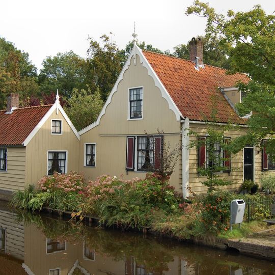 Houten huis met zadeldak. Gesneden deur in Lodewijk XVI-stijl