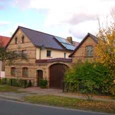 Bauernhof mit Wohnhaus, Ausgedingehaus, Seitengebäude, Hofmauer mit großem Torbogen und kleiner Pforte Dorfstraße 80