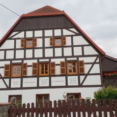 Wohnstallhaus (ohne Anbau) und Einfriedungsmauer eines Dreiseithofes Hauptstraße 50