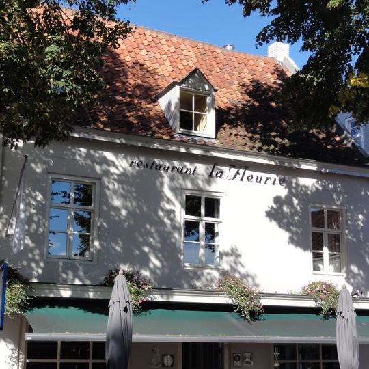 Huis onder zadeldak tussen zij-topgevels, gepleisterde voorgevel