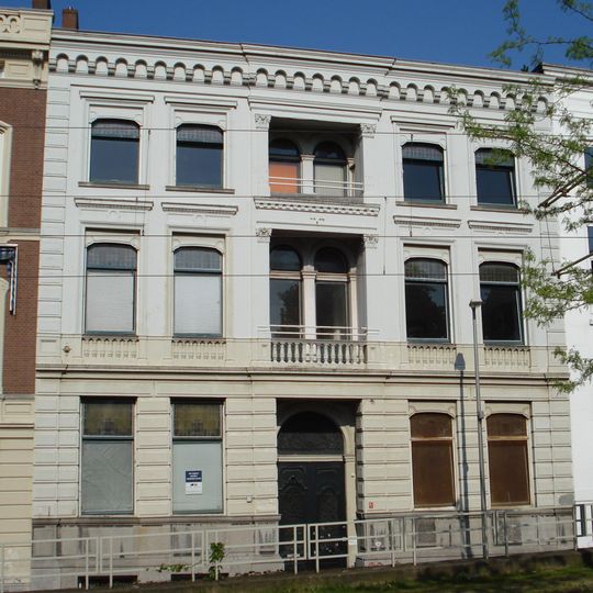 Herenhuis met gepleisterde lijstgevel. Middenpartij met loggia's, stucversieringen en kroonlijst op uitgekraagd boogfries