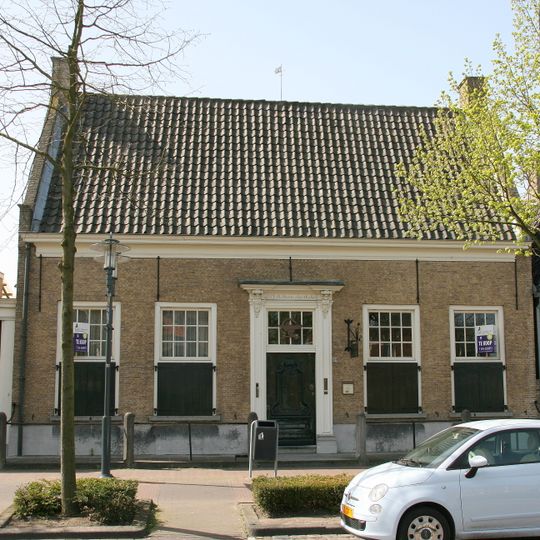 Mooi dorpshuis met twee dwarse zadeldaken achter elkaar tussen zijtopgevels