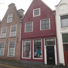 Pand onder zadeldak tegen vereenvoudigde topgevel