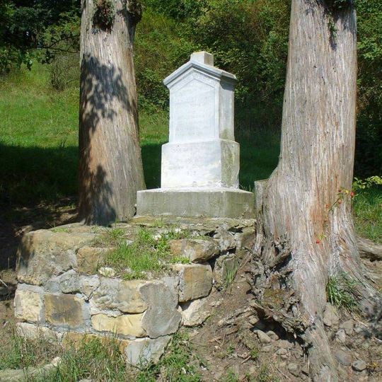 Podstavec s ulomeným křížem u polní cesty západně od osady Hliněná