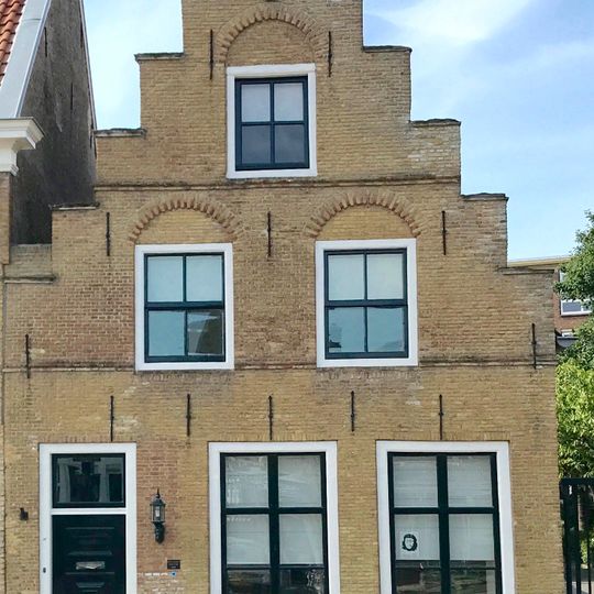 Pand onder zadeldak tussen trapgevel met waterslagen met toppilaster op kopje en puntvormige achtergevel