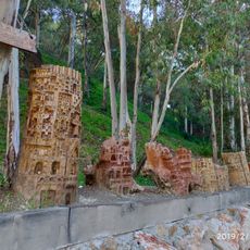 Tocón de eucalipto tallado a modo de escultura simulando un edificio o ciudad medieval abigarrada.