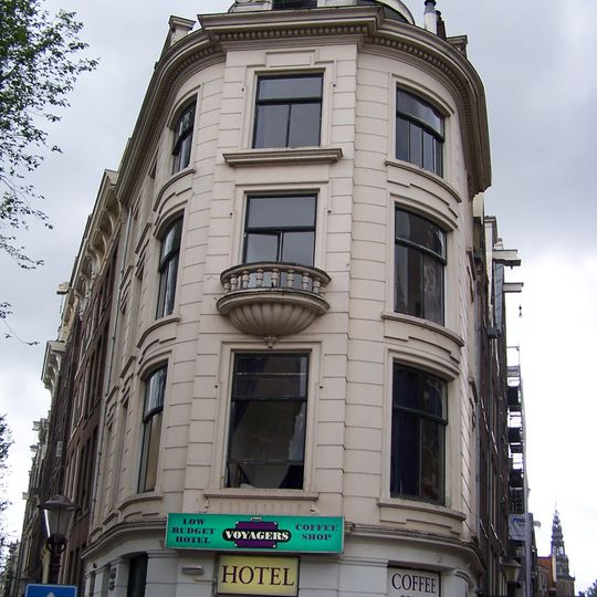 Hoekhuis met gepleisterde gevels en balcon in de hoekpartij