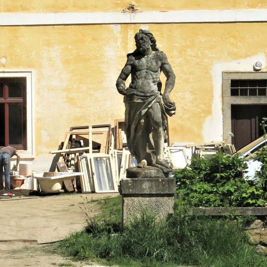 Socha vpravo u brány k hospodářskému stavení v zámeckém parku v Chlumu u Třeboně