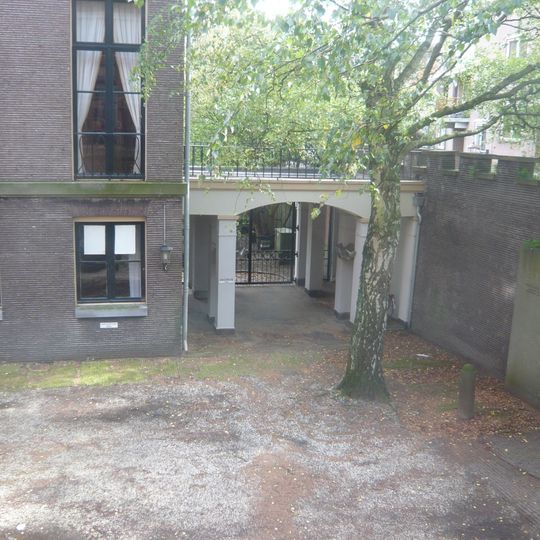 Rear entrance of Hodshon House with iron gate and gravestone