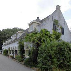 Gepleisterde lage huizen, ramen met kleine roeden en halve luiken, topgevel en zadeldak