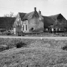 Aan de achterzijde van het pand een houten schuur onder zadeldak en met gesneden gevelbekroning.