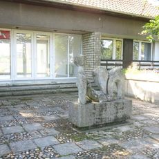 Kamenná plastika ženy u domu Komenského 449 v Peruci