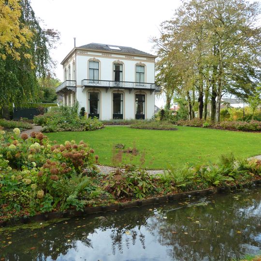 Blokvormig wit gepleisterd landhuis met flauw hellend dak