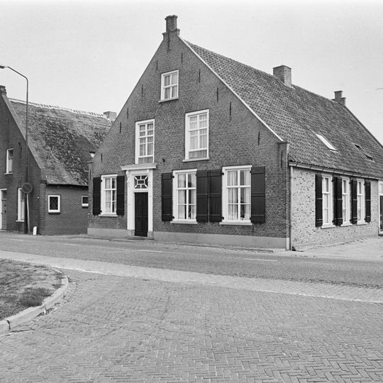 Huis van het langstraatse dorpswoningtype met topgevel bekroond door trappen en toppilaster