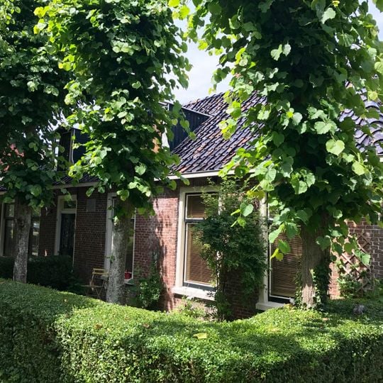 Dubbel pand met goot op klossen onder schilddak