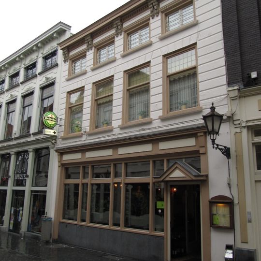 Huis met gebosseerd witgepleisterde lijstgevel en rijke kroonlijst op consoles