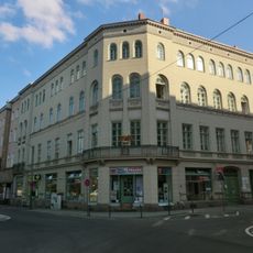 Mietshaus mit Läden in geschlossener Bebauung, Eckhaus Wilhelmsplatz 16 (Hauptanschrift: Jakobstraße 6)